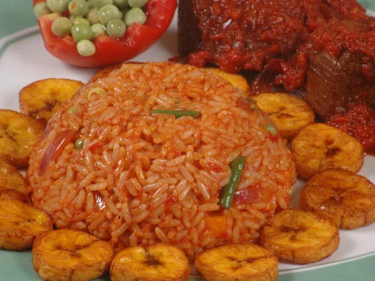 Plate of Nigerian jollof rice with plantain and grilled chicken